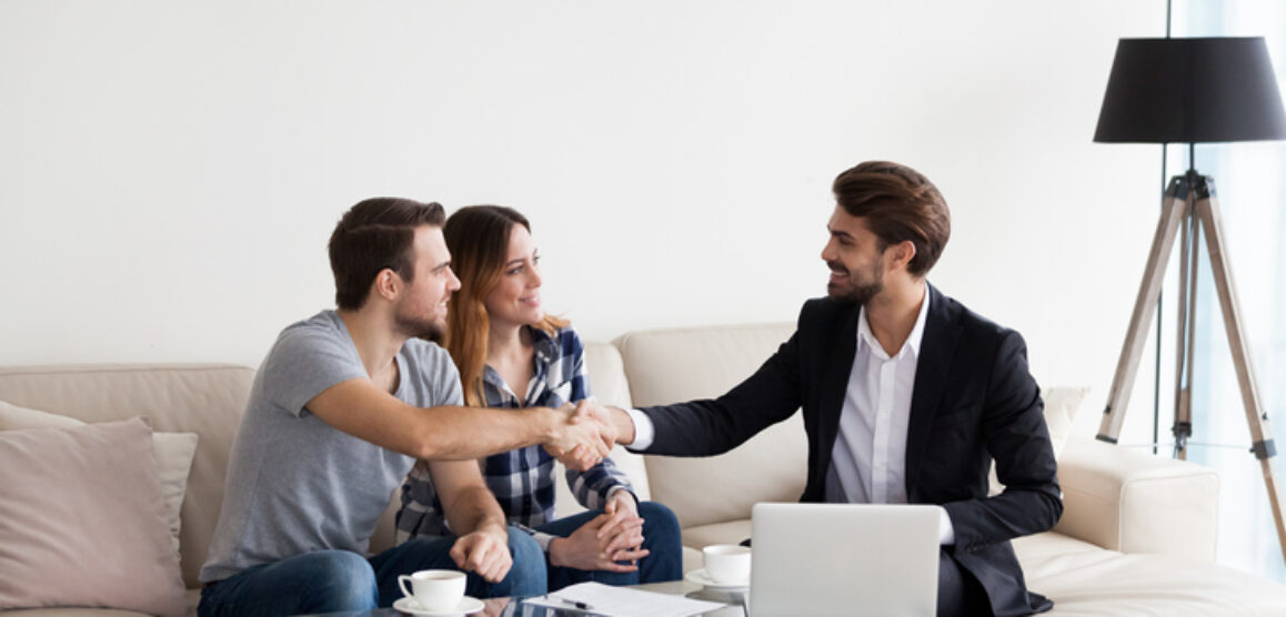 Young couple, family making deal with realtor, interior designer